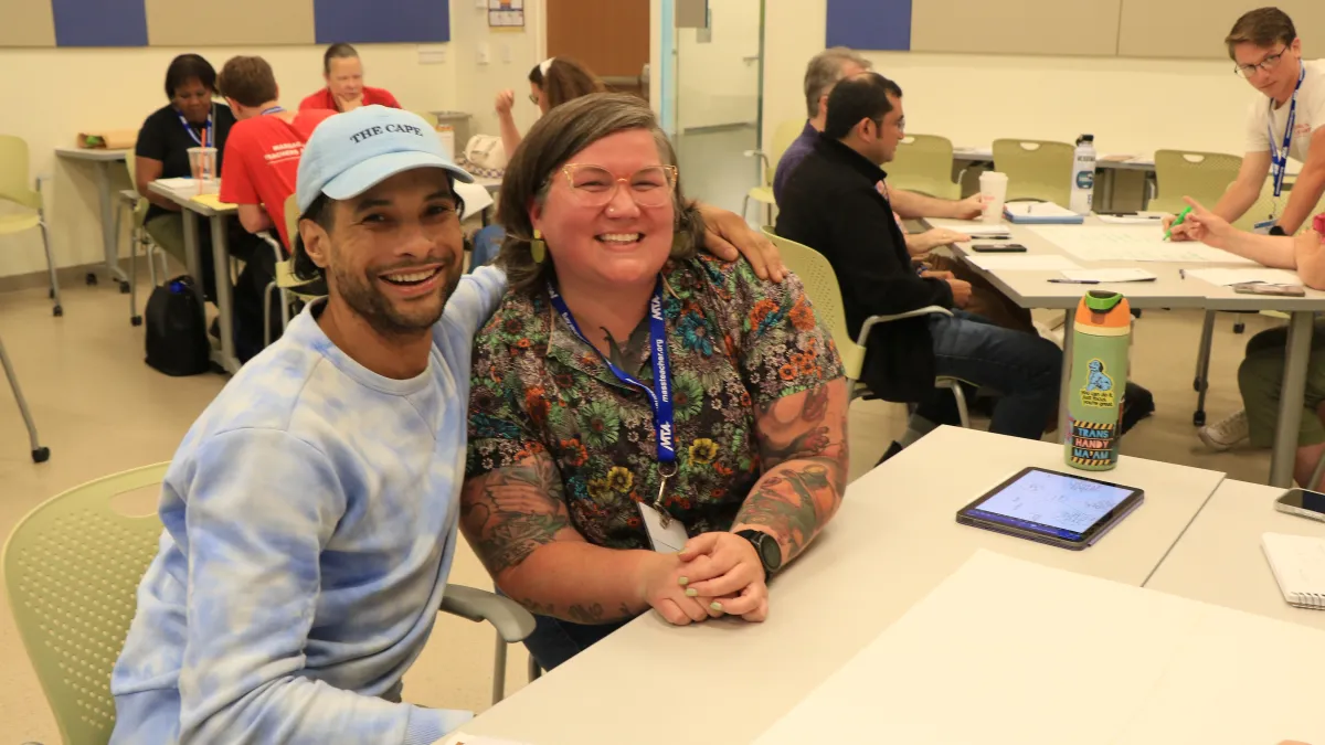 Two MTA new members seated together in a classroom at UMass Amherst during the MTA Summer Conference