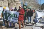 Professional Staff Union members in Amherst carry a banner through campus.