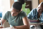Two students working at desks in a classroom.