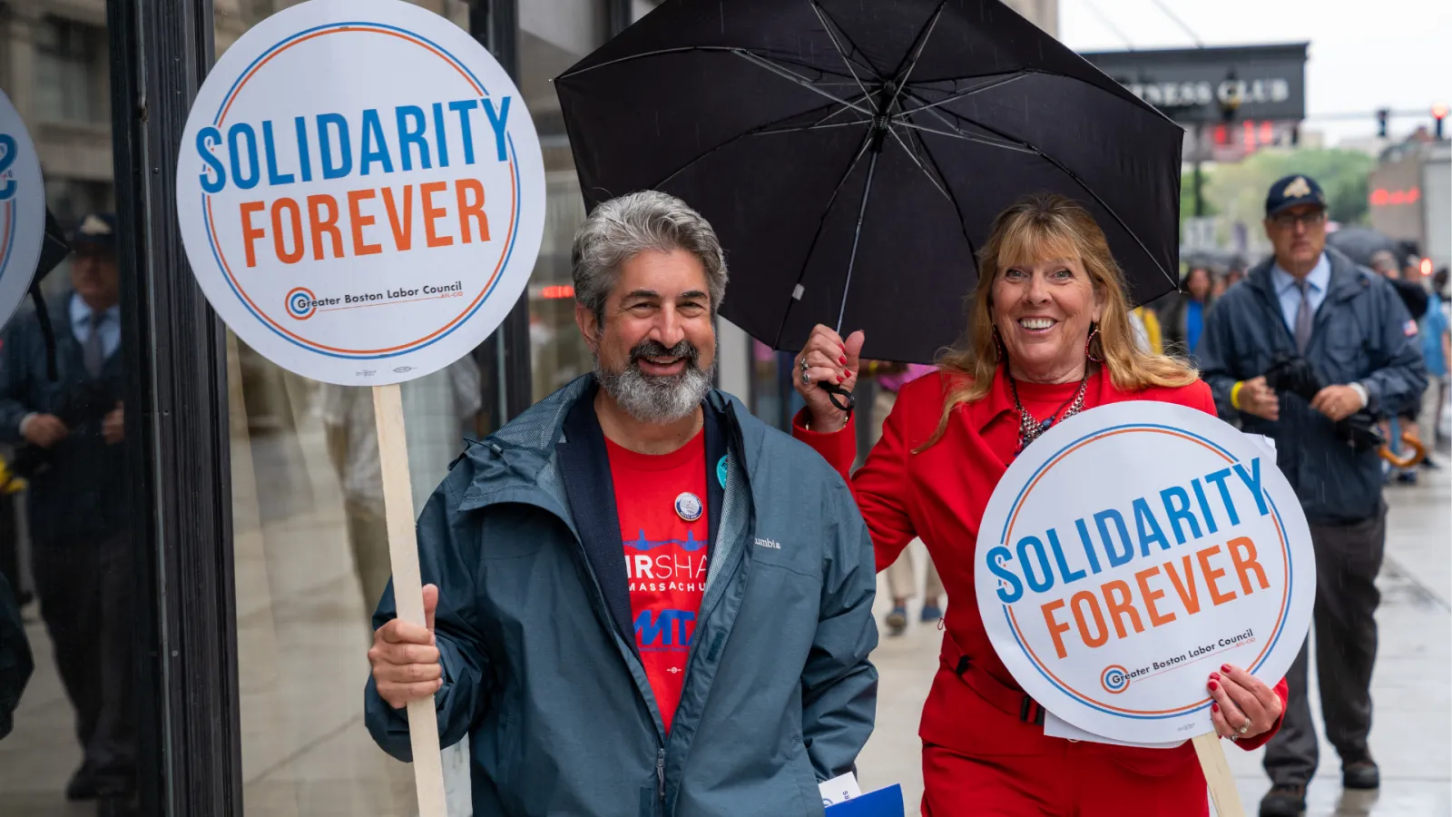 Max Page and Deb McCarthy at a Boston rally holding “Solidarity Forever” signs.