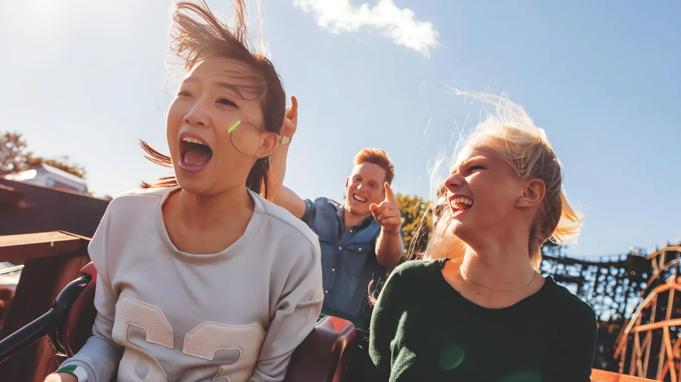 People riding a roller coaster at an amusement park