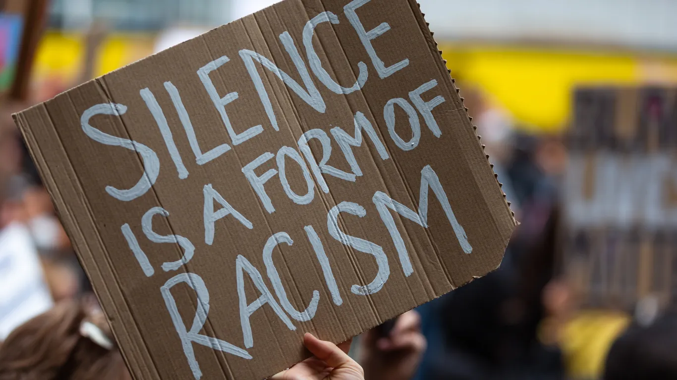 Sign reads, “Silence is a form of racism.”