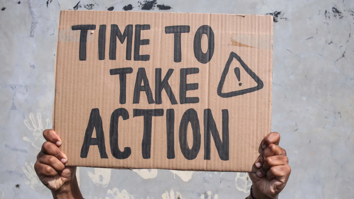 Sign reading “Time to Take Action.”