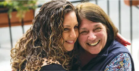 paula higgins shares a hug with malden education association president deb gesualdo