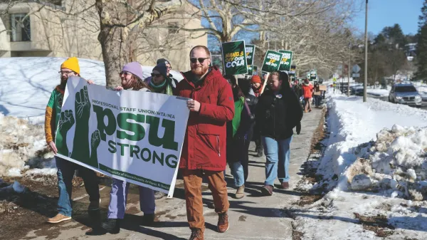 Professional Staff Union members in Amherst carry a banner through campus.